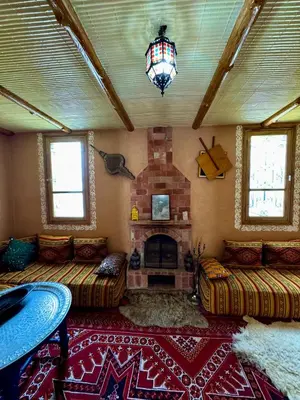 a living room with two couches and a fireplace at Villa Mouloud, Authentic Amazigh Family Villa, Fireplace & Garden in Khenifra