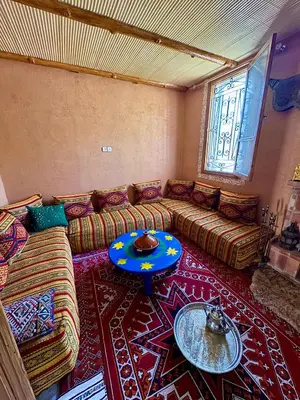 a living room with couches and a table on a rug at Villa Mouloud, Authentic Amazigh Family Villa, Fireplace & Garden in Khenifra