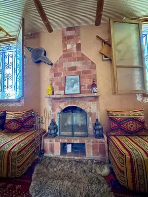 a brick fireplace in a room with two beds at Villa Mouloud, Authentic Amazigh Family Villa, Fireplace & Garden in Khenifra