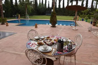 a table with food on it next to a pool at Les jardins d’ailleurs in Marrakech