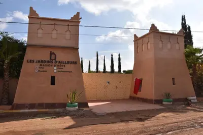 a building with two towers next to a fence at Les jardins d’ailleurs in Marrakech