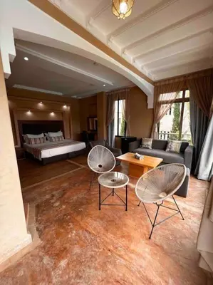 a living room with two chairs and a couch at Les jardins d’ailleurs in Marrakech