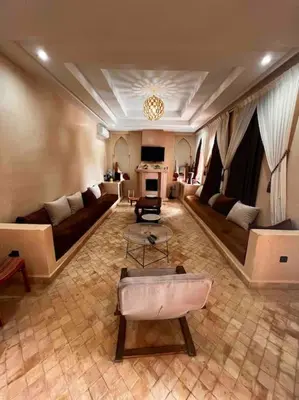 a large living room with couches and a fireplace at Les jardins d’ailleurs in Marrakech
