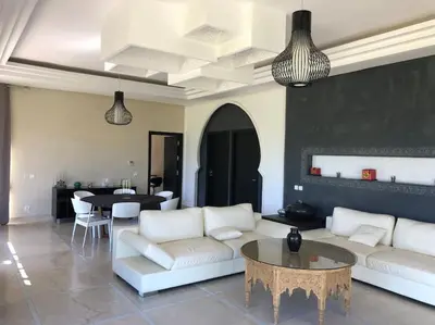 a living room with a couch and a table at Villa privée dans un environnement idyllique in Marrakech