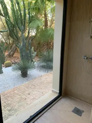 an open door to a garden with a cactus at Villa privée dans un environnement idyllique in Marrakech