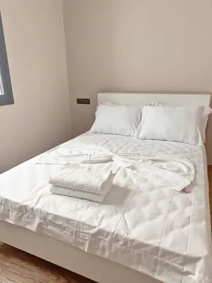 a white bed with white sheets and pillows on it at Family confort Fes in Fès