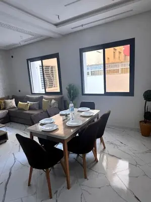 a living room with a wooden table and chairs at Family confort Fes in Fès