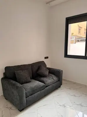 a couch sitting in a living room with a mirror at Family confort Fes in Fès