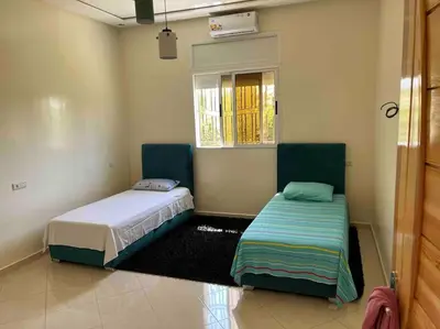 a bedroom with two beds and a window at Maison Dar Zarka in Aghmat