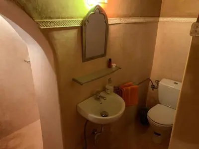 a bathroom with a sink and a toilet and a mirror at Kasbah Hotel Ait Omar in Nkob