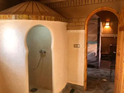 a room with a shower in a room with a mirror at Kasbah Hotel Ait Omar in Nkob