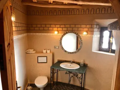 a bathroom with a sink and a mirror at Kasbah Hotel Ait Omar in Nkob