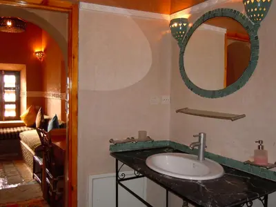 a bathroom with a sink and a mirror at Kasbah Hotel Ait Omar in Nkob