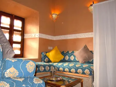 a living room with a blue couch and a table at Kasbah Hotel Ait Omar in Nkob