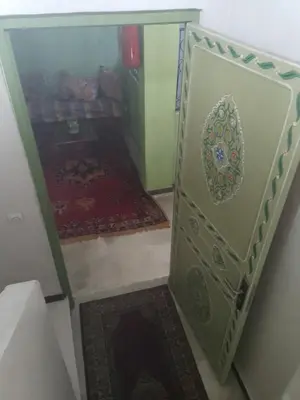 a small room with a door with a rug at Hotel Des voyageur in Ouarzazate
