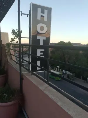 a sign on a balcony with a view of a street at Hotel Des voyageur in Ouarzazate