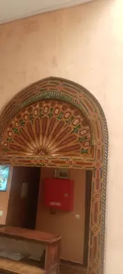 an archway in a room with a wooden table at Hotel Des voyageur in Ouarzazate