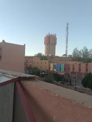 a view of a city with a water tower in the background at Hotel Des voyageur in Ouarzazate