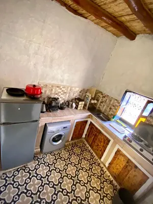 a small kitchen with a stove and a sink at chez aubazine in Merzouga