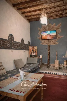 a living room with a couch and a tv at chez aubazine in Merzouga