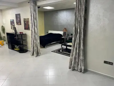 a living room with curtains and a room with a couch at Cozy Downtown Apartment in Fès