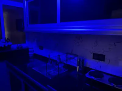 a dark kitchen with two sinks and a blue light at Cozy Downtown Apartment in Fès