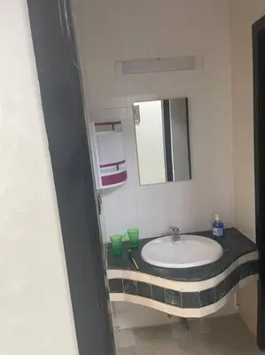a bathroom with a sink and a mirror at Cozy Downtown Apartment in Fès