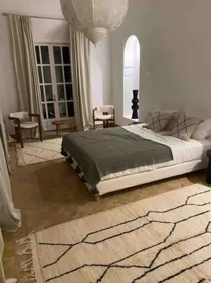 a bedroom with a bed and a living room at Villa-Riad Nejma in Marrakech