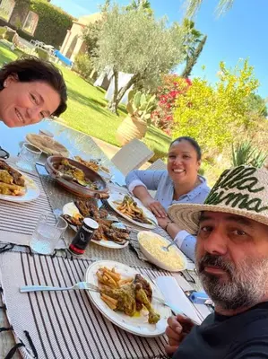 a man and woman sitting at a table with food at Villa-Riad Nejma in Marrakech