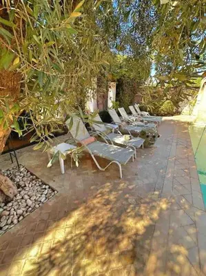 a group of lounge chairs sitting under a tree at Villa-Riad Nejma in Marrakech