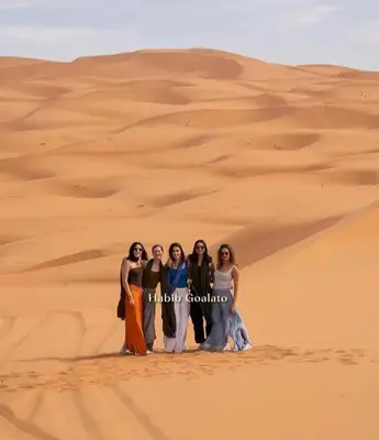 a group of women standing in the desert at Merzouga Luxurious Camp in Merzouga