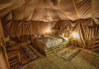 a bedroom with a bed in a tent at Morocco travel activities in Merzouga