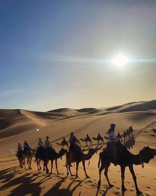a group of people riding horses in the desert at Morocco travel activities in Merzouga