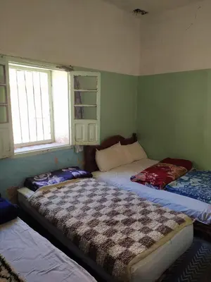 a room with three beds in it with a window at hotel atlas in Imilchil