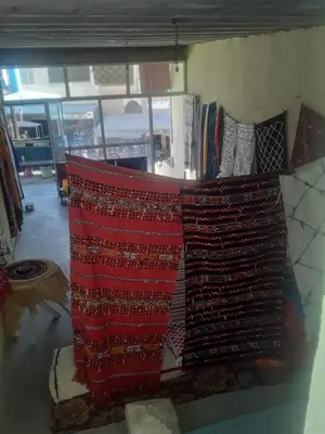 a pile of blankets on a shelf with books at hotel atlas in Imilchil