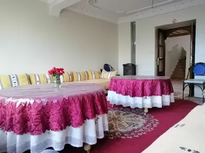two tables in a room with a couch at Gite chez Ali Agouti Maison Berbère in Agouti