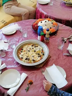 a table with two pizzas on a pink table cloth at Gite chez Ali Agouti Maison Berbère in Agouti