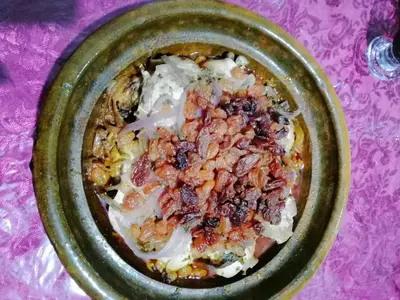 a green bowl filled with food on a purple table at Gite chez Ali Agouti Maison Berbère in Agouti