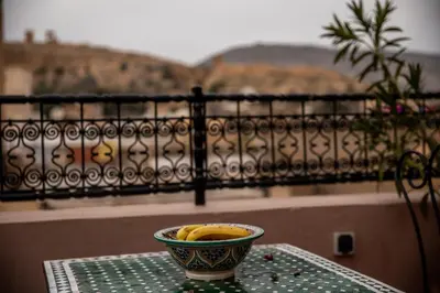 a bowl of bananas sitting on a table in front of a balcony at Dar Elhaja Rahma in Fès
