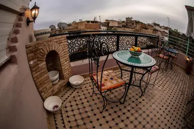 a balcony with a table and a tableasteryasteryasteryasteryasteryasteryasteryastery at Dar Elhaja Rahma in Fès