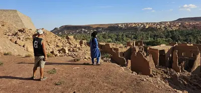 two people standing on top of a hill with a view at Auberge ALI Todra A Natural Oasis in Tinerhir