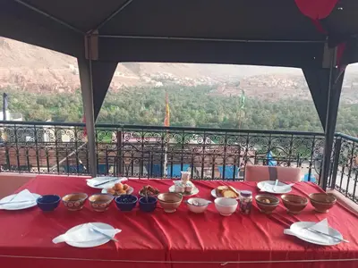 a table with bowls of food on a red table cloth at Auberge ALI Todra A Natural Oasis in Tinerhir