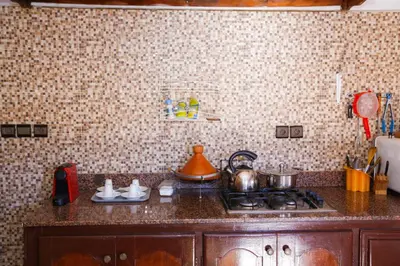 a kitchen counter with a stove and a tea kettle at Elhachimi two bedroom with air conditioning in Er Rachidia