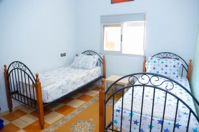 two twin beds in a room with blue walls at Elhachimi two bedroom with air conditioning in Er Rachidia