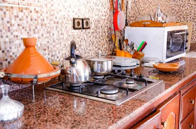 a kitchen counter with pots and pans on a stove at Elhachimi two bedroom with air conditioning in Er Rachidia