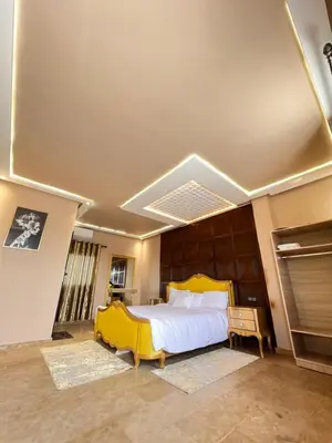 a bedroom with a large bed with a yellow headboard at Auberge Salle billionaire in Fès