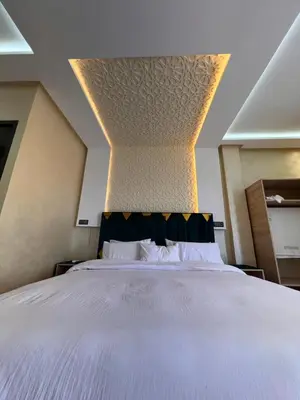 a bedroom with a large white bed with a ceiling at Auberge Salle billionaire in Fès