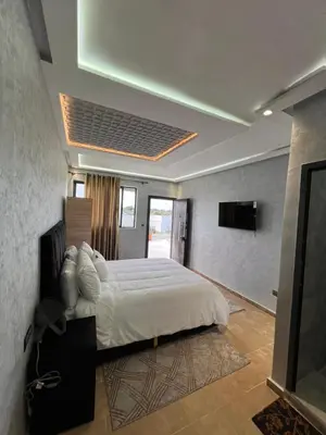 a bedroom with a large bed and a television at Auberge Salle billionaire in Fès