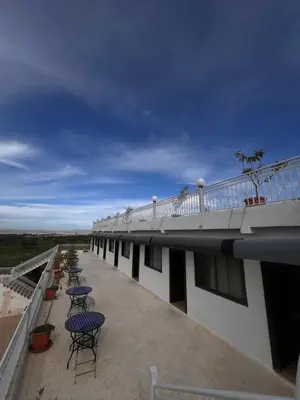 a balcony with chairs and tables on top of a building at Auberge Salle billionaire in Fès