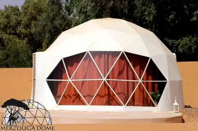 a white tent with a red door in the desert at Merzouga Dome in Merzouga